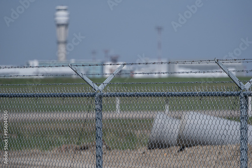 Airport security fence with control tower in background