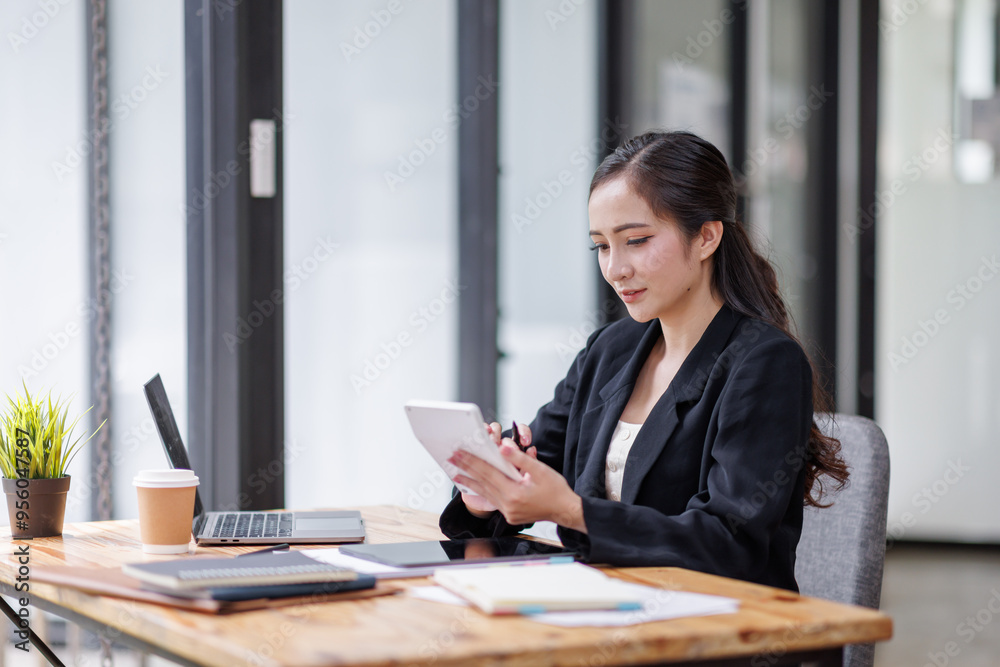 Business woman accountant with documents calculating numbers for a financial audit and taking notes with a silver pen. Taxes and audit concept. Business woman accountant with documents calculating numbers for a financial audit and taking notes with a silver pen. Taxes and audit concept.