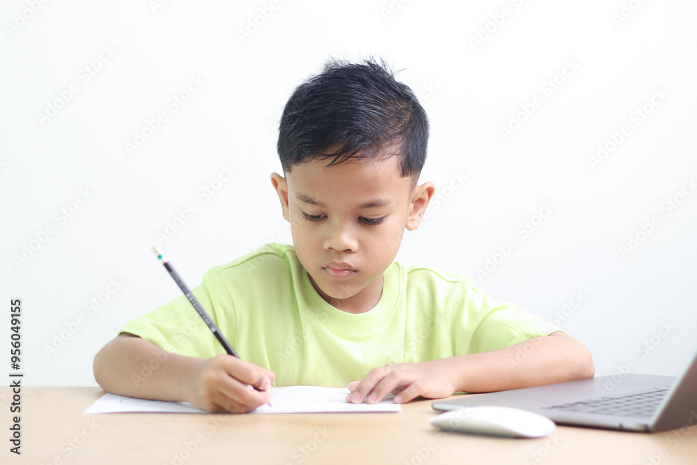 A Happy little asian boy studying online learning class with online video call zoom teacher at home. E-learning or Home schooling education concept. A Happy little asian boy studying online learning class with online video call zoom teacher at home. E-learning or Home schooling education concept.