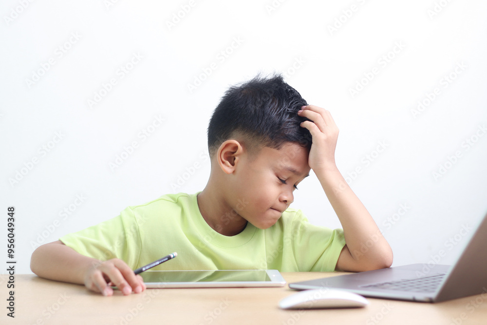 A Happy little asian boy studying online learning class with online video call zoom teacher at home. E-learning or Home schooling education concept. A Happy little asian boy studying online learning class with online video call zoom teacher at home. E-learning or Home schooling education concept.