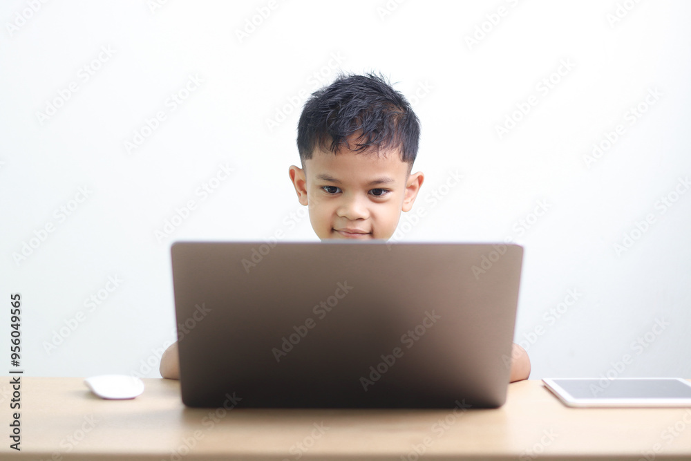 A Happy little asian boy studying online learning class with online video call zoom teacher at home. E-learning or Home schooling education concept. A Happy little asian boy studying online learning class with online video call zoom teacher at home. E-learning or Home schooling education concept.