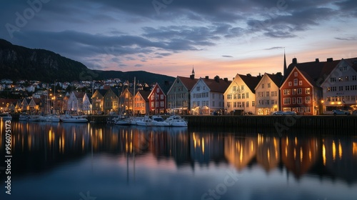 Dusk at Bergen's Bryggen harbor, with the historic buildings illuminated against a serene sky and reflections dancing on the water