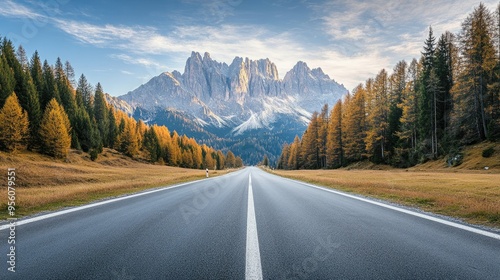 Peaceful empty road in Venegia Valley, with sharp Dolomite peaks rising in the background, under the early morning light. photo