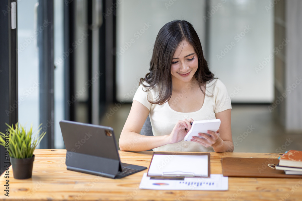 Businesswomen or Asian Accountants using calculator and a tablet laptop computer to analyze business report graphs and finance charts at the workplace, financial and investment concept.
Businesswomen or Asian Accountants using calculator and a tablet laptop computer to analyze business report graphs and finance charts at the workplace, financial and investment concept.