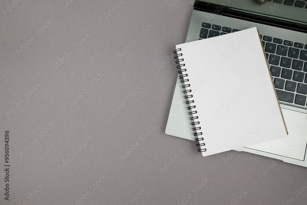 laptop and notepad on gray background, top view, copy space laptop and notepad on gray background, top view, copy space
