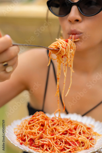 Obraz na plátně woman in park eating pasta with tomatoes and drinking wine