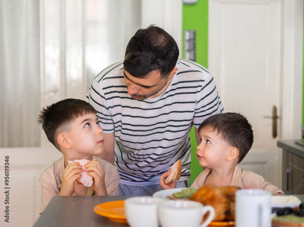 dad and sons, man and kids having breakfast in modern kitchen.father making healthy sandwich. plates with food on counter.hungry siblings waiting to eat.family spending time together. dad and sons, man and kids having breakfast in modern kitchen.father making healthy sandwich. plates with food on counter.hungry siblings waiting to eat.family spending time together.