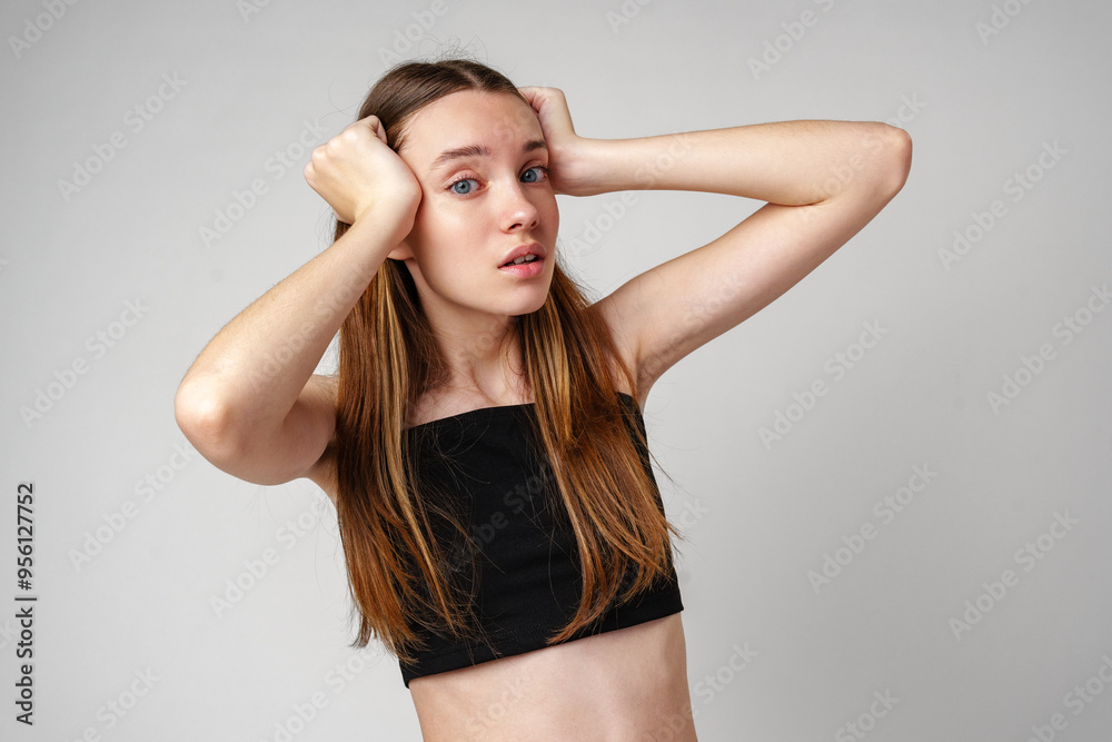 Young Woman With Long Brown Hair Holds Her Head in Shock Young Woman With Long Brown Hair Holds Her Head in Shock
