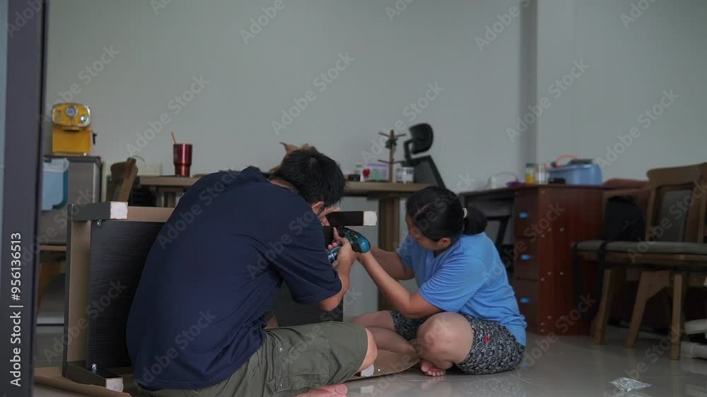 An Asian couple assembled a wooden table for use in their home An Asian couple assembled a wooden table for use in their home