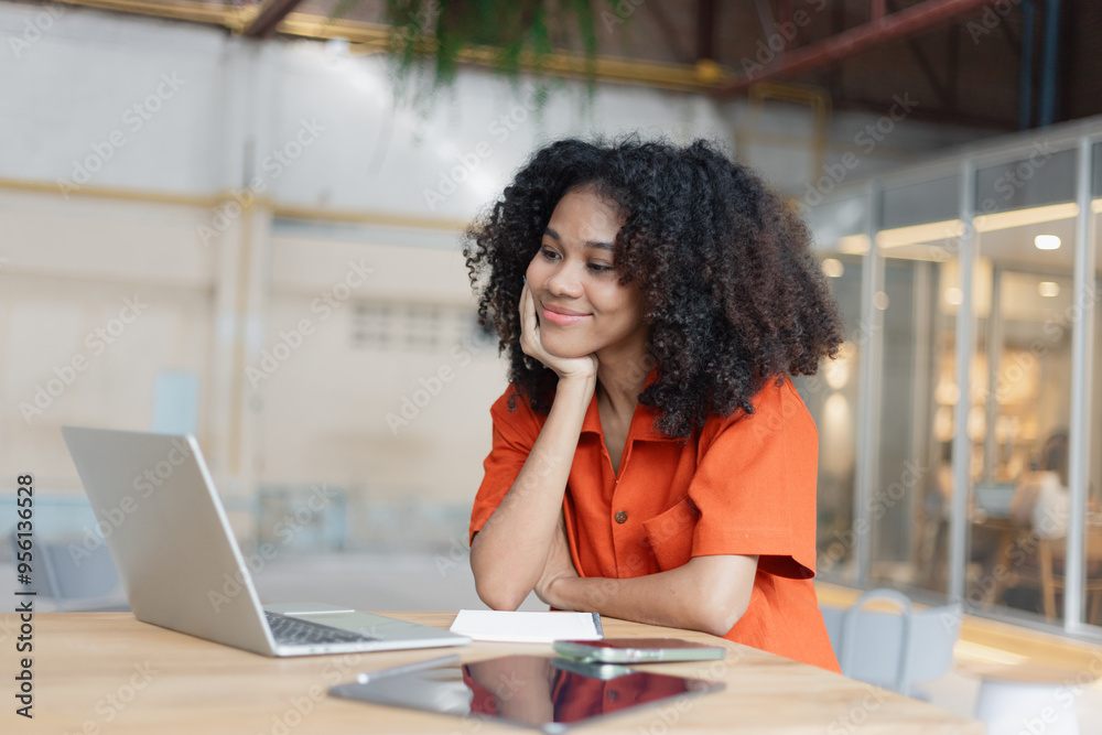 Obraz premium About successful young woman concept. Excited African American woman sitting at working desk.
