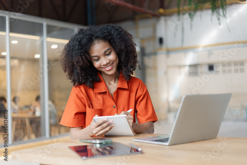 About successful young woman concept. Excited African American woman sitting at working desk.