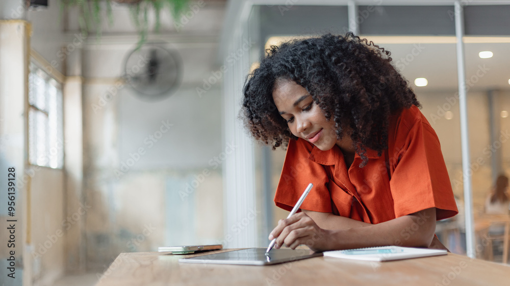 African American businesswoman excited by the good news on the tablet sitting at office desk. African American businesswoman excited by the good news on the tablet sitting at office desk.