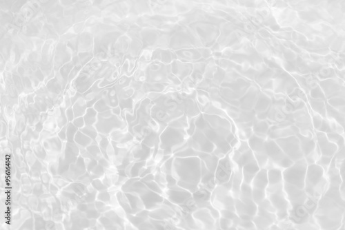 White water with ripples on the surface. Defocus blurred transparent white colored clear calm water surface texture with splashes and bubbles. Water waves with shining pattern texture background.