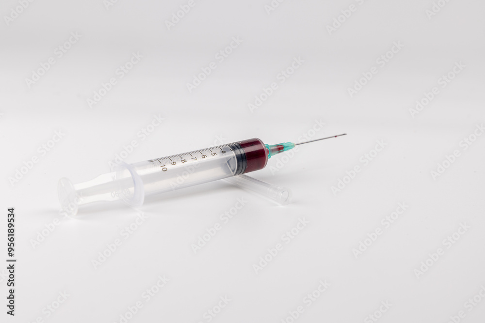 Horizontal View of Syringe with Blood on White Surface Horizontal View of Syringe with Blood on White Surface