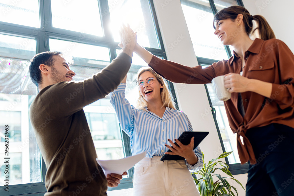 © Westend61 - Happy business colleagues doing high-five standing in office © Westend61 - Happy business colleagues doing high-five standing in office
