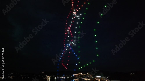 light show by drones over city at night photo