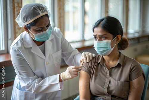 Indian Nurse Administering Vaccine - An Indian nurse giving a vaccine to a patient in a hospital.
 photo