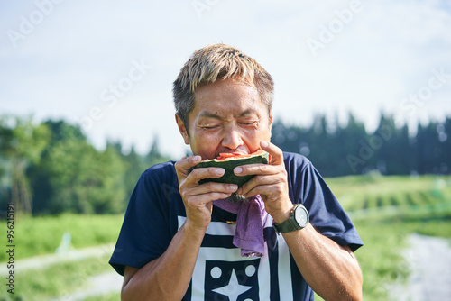 収穫した小玉スイカの味見をする日本の農家さん photo