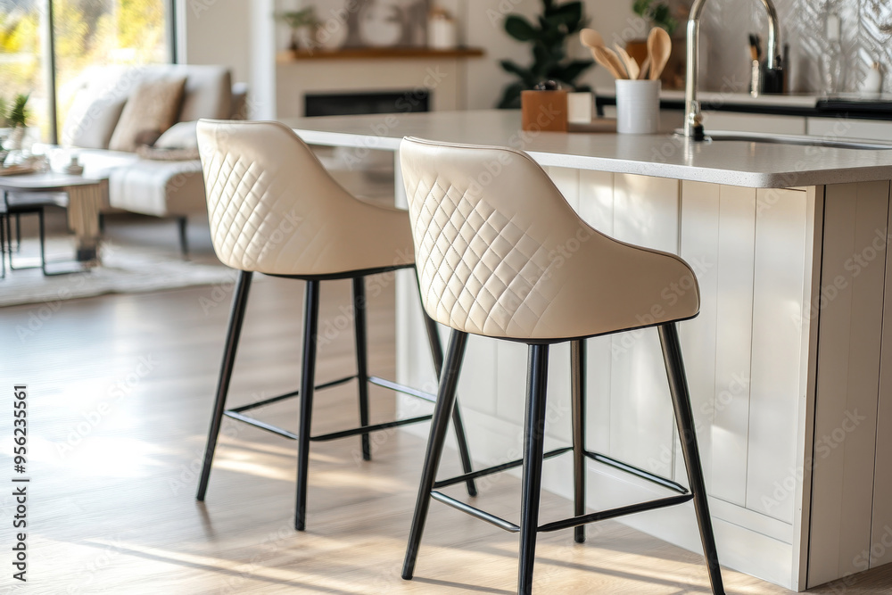 Beige leatherette barstools with quilted backrest and black metal base in boho-style kitchen island setting. Beige leatherette barstools with quilted backrest and black metal base in boho-style kitchen island setting.