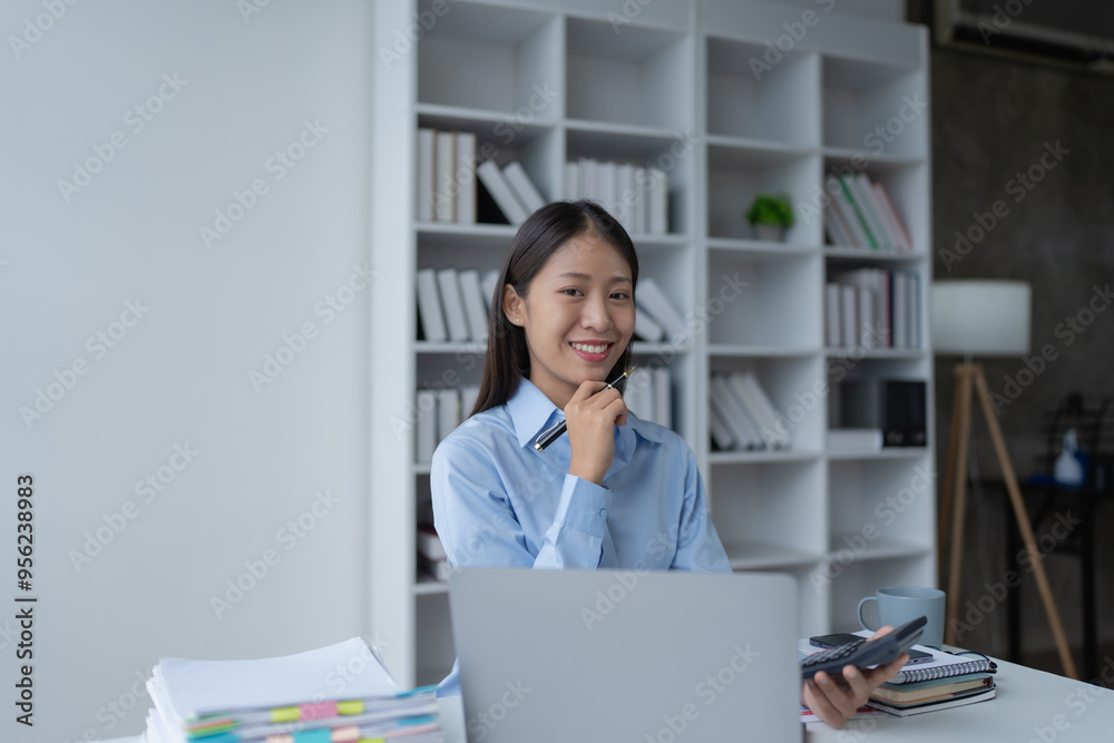 woman meticulously plans a finance audit, using a computer and calculator to review budget documents and ensure accuracy woman meticulously plans a finance audit, using a computer and calculator to review budget documents and ensure accuracy