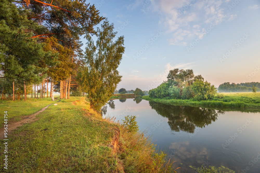 A peaceful scene of a river with trees and grass in the background A peaceful scene of a river with trees and grass in the background