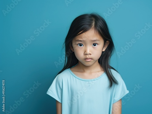 Cyan background sad Asian child Portrait of young beautiful in a bad mood child Isolated on Background, depression anxiety fear burn out health 