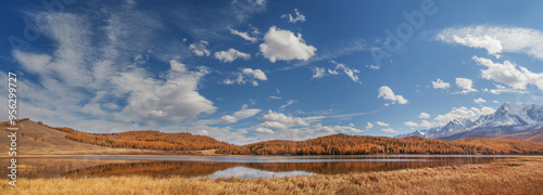 Foto Autumn landscape with a lake, picturesque sky with white clouds, forested slopes