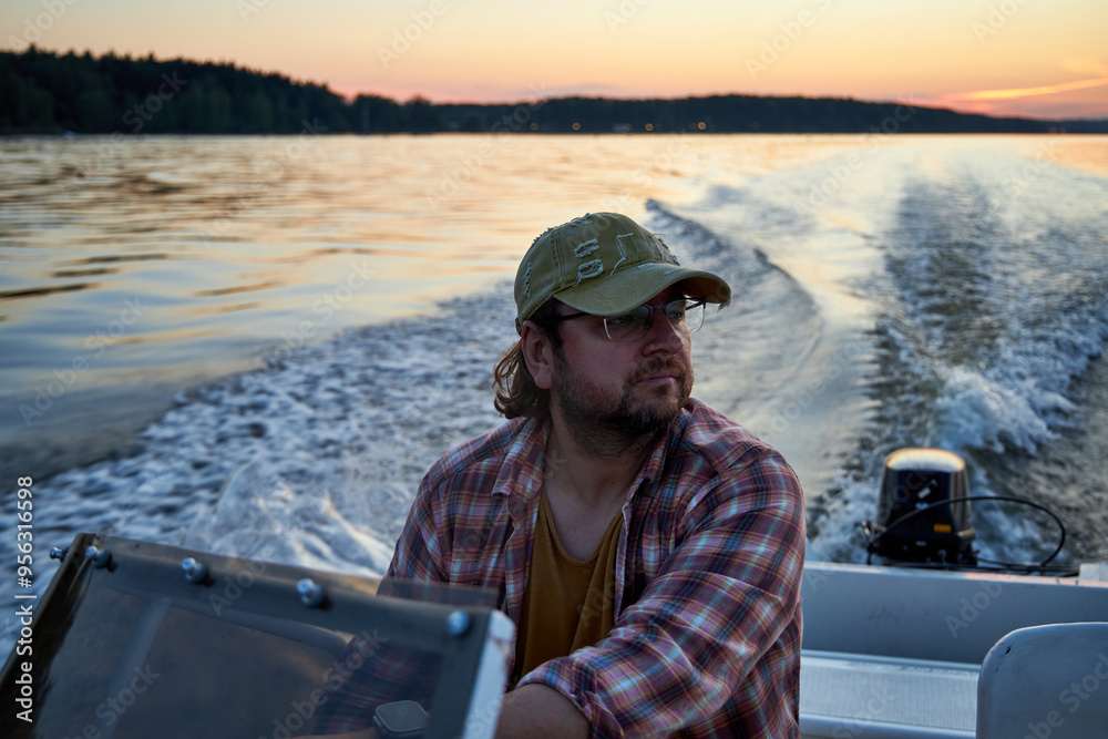 a man driving a boat on the river in the evening at sunset a man driving a boat on the river in the evening at sunset