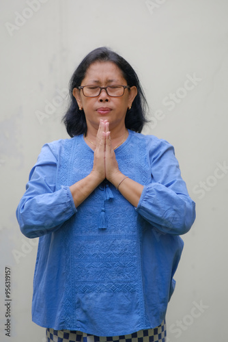 Woman standing alone with her eyes closed praying quietly photo