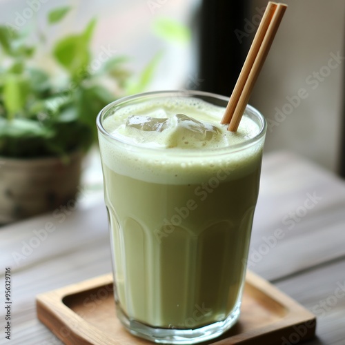 A refreshing glass of iced matcha latte with two bamboo straws. photo