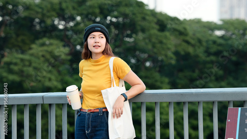 Go green Gen Z woman asia young people looking away in city life nature tree public park reuse cup eco tote bag save the earth world care reduce issues asian future hope net zero waste the way forward photo