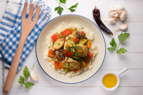 Wok-fried calmares with vegetables over white rice. Food on top view table. photo