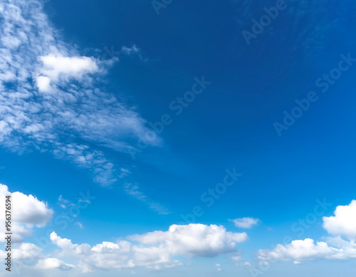 Blue sky with a few clouds. The sky is very bright and the clouds are scattered throughout