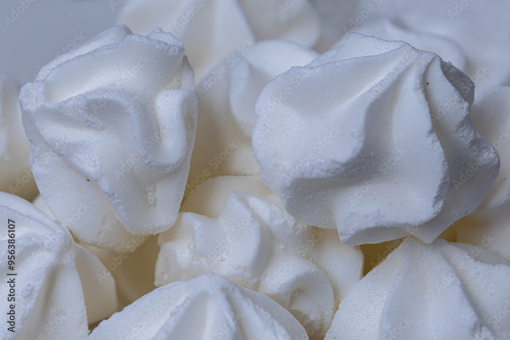 Porcelain plate full of fluffy white meringue. Indoors close-up.