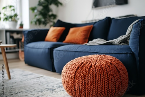 Two knitted poufs positioned near a dark blue corner sofa, showcasing a Scandinavian design in the modern living room. photo