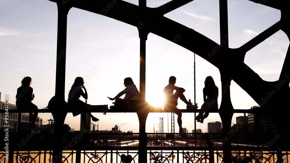 Junge Menschen Stadtbewohner genießen den Sonnenuntergang Feierabend Freizeit Freundschaft Wochenende auf einer Brücke vor urbaner städtischer Kulisse Hackerbrücke München