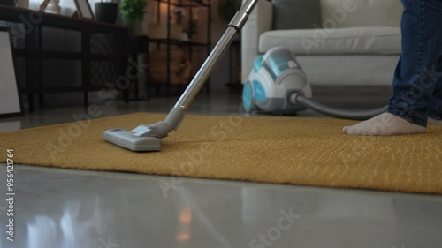 Adult man vacuums carpet with a vacuum cleaner do housework chores