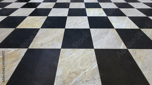 A black and white checkered floor with a white marble tile. The floor is clean and shiny
