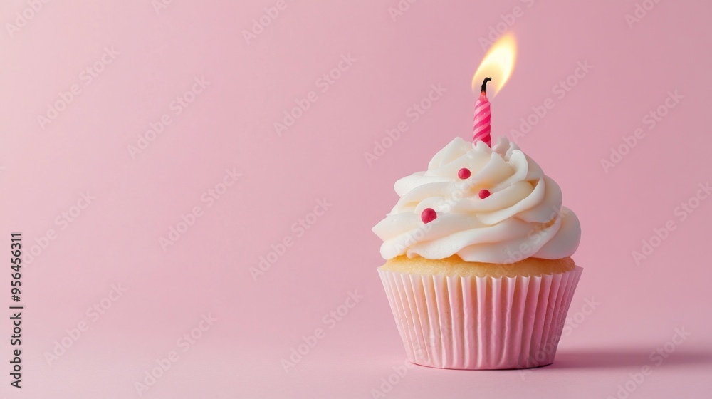 single cupcake with a burning candle on pink background single cupcake with a burning candle on pink background