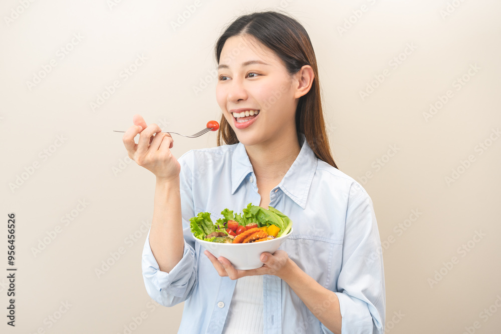 Diet concept, happy smile asian young woman use fork to prick tomato, fresh vegetable or green salad, eat nutrition food isolated on background, low fat to good body, getting weight loss for healthy. Diet concept, happy smile asian young woman use fork to prick tomato, fresh vegetable or green salad, eat nutrition food isolated on background, low fat to good body, getting weight loss for healthy.
