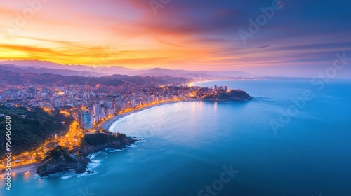 Aerial a coastal city at twilight, where the ocean meets the urban landscape, with lights beginning to glow along the waterfront