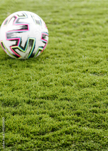  Green Artificial Grass with a Blurred Colourful Football in the Background