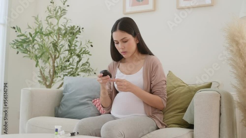 Pregnant woman checking blood sugar level by using Digital Glucose meter