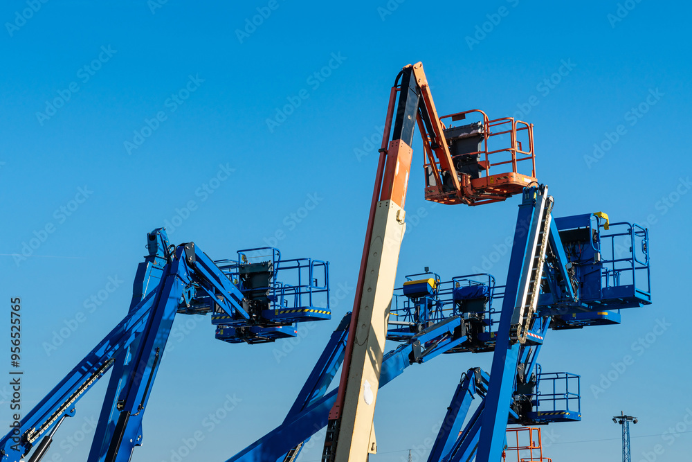 Cluster of boom lifts at a construction site. Cluster of boom lifts at a construction site.