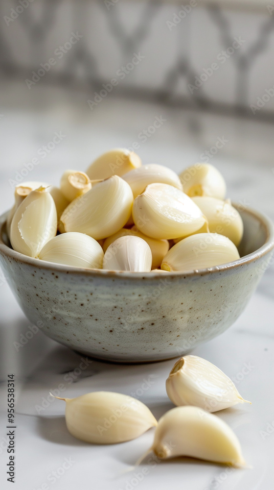 Bowl of Fresh Peeled Garlic Cloves on Marble Kitchen Counter Bowl of Fresh Peeled Garlic Cloves on Marble Kitchen Counter