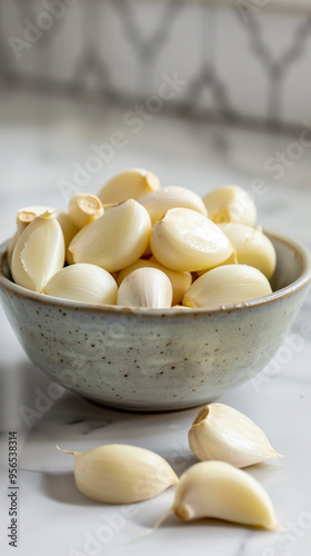 Bowl of Fresh Peeled Garlic Cloves on Marble Kitchen Counter