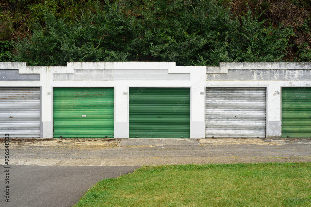 Fila de puertas de garage en diferentes tonos de verde Fila de puertas de garage en diferentes tonos de verde