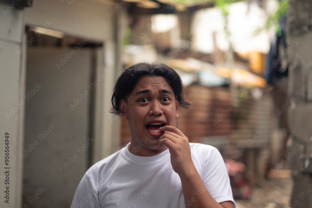 Φωτογραφία A young Filipino man with wide eyes, panicking and unsure of what to do