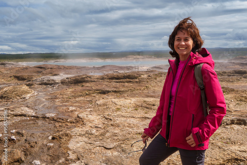 Woman in pink jacket enjoying geothermal landscape, Iceland photo