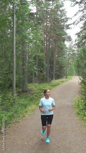 Athletic young woman running in a national park in Finland, doing sports in the park, staying fit by exercising
